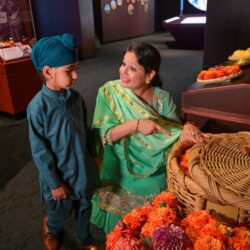 A Group Of People Sitting At A Fruit Stand