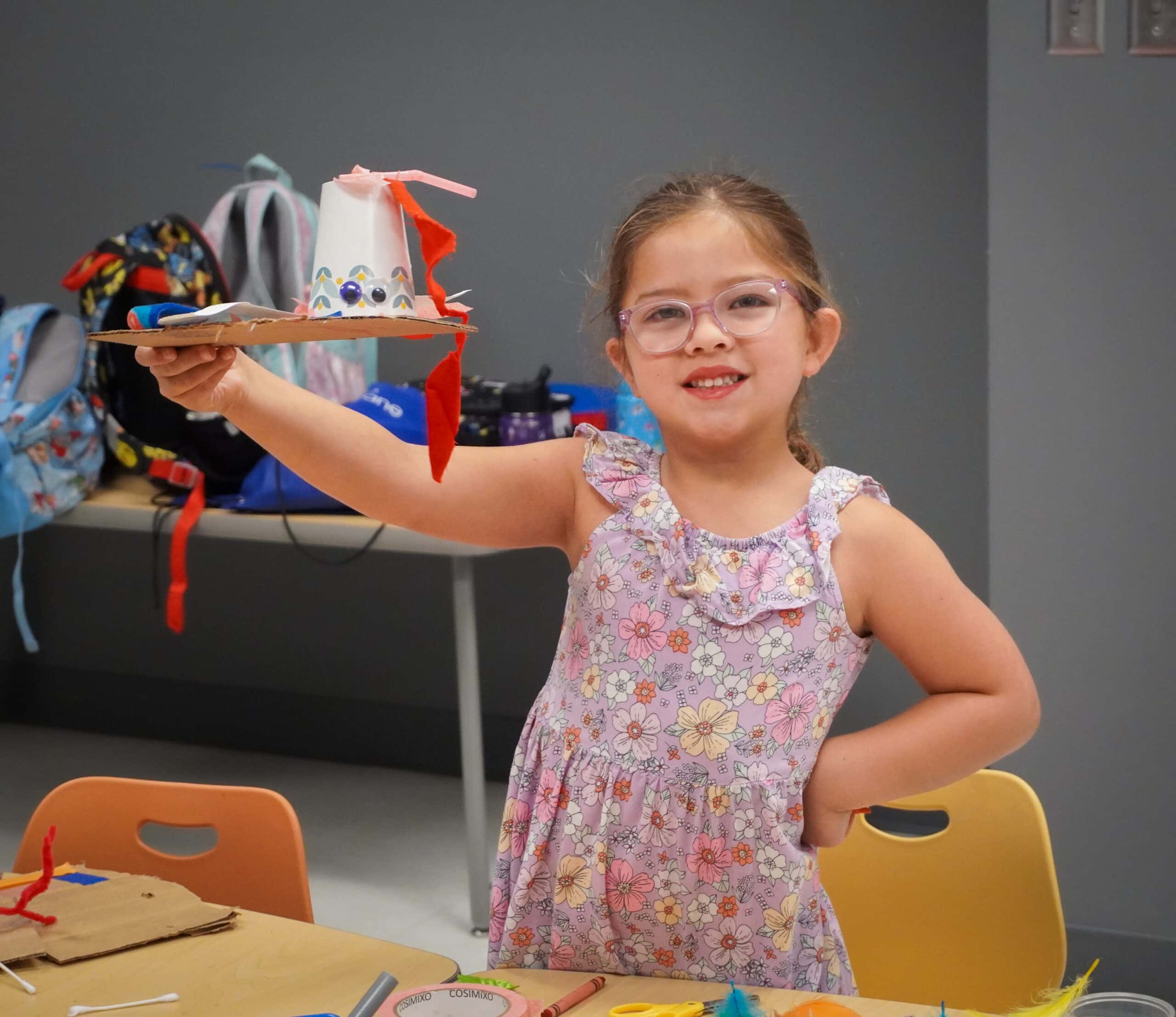 Child holding a camp craft creation